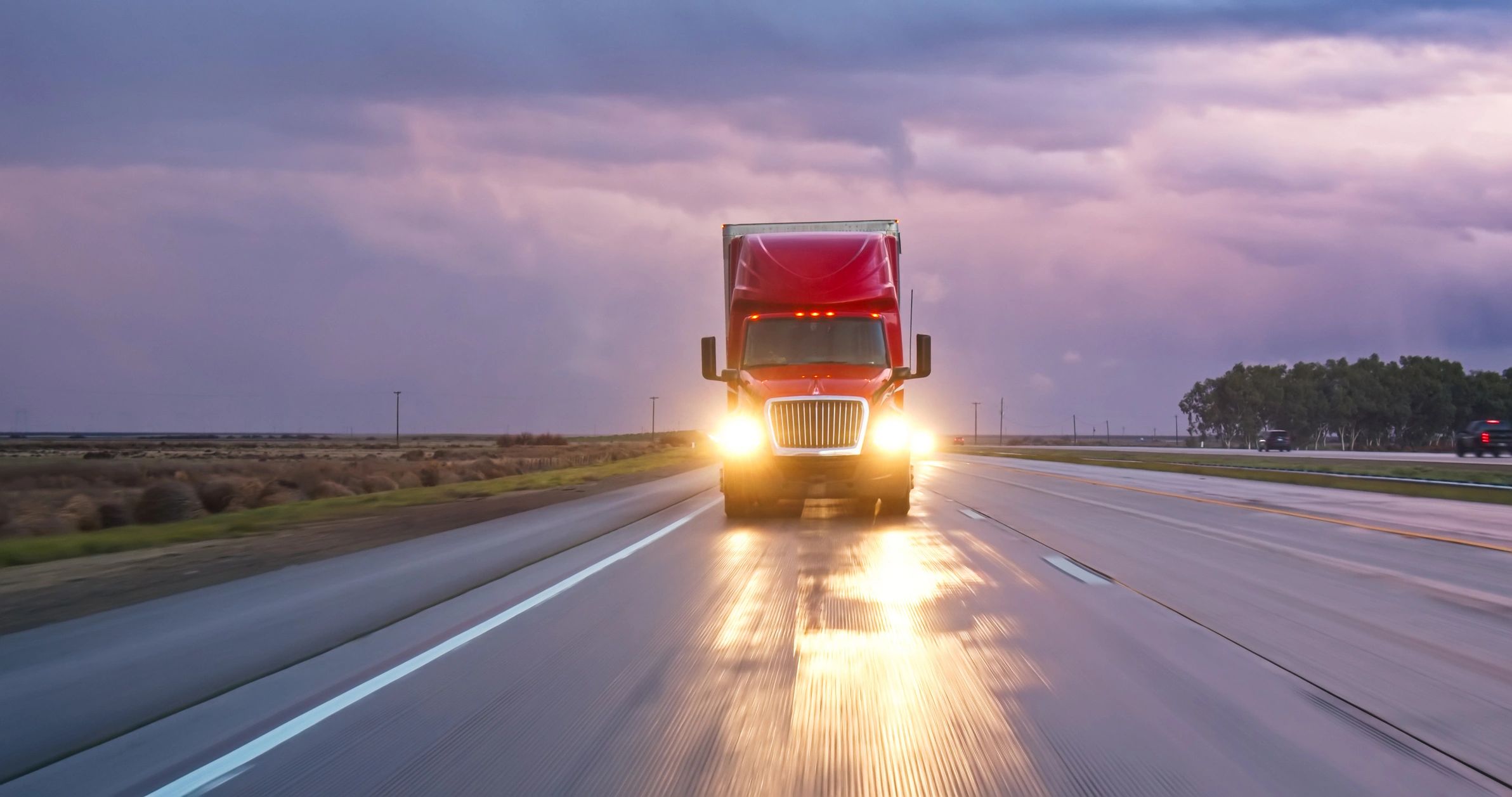 Cargo truck driving on interstate at sunset